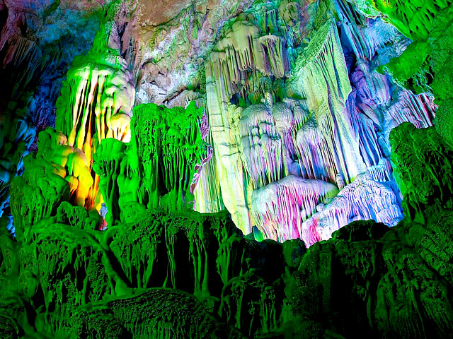 Stalactites inside Reed Flute Cave illuminated by colored lighting