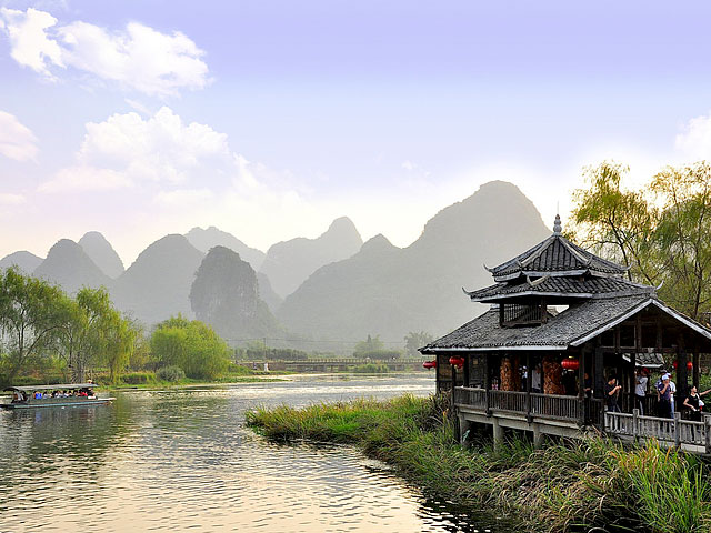 Classic tranquil scenery of Yangshuo town with ancient-style house by Li River and Karst landscape as background