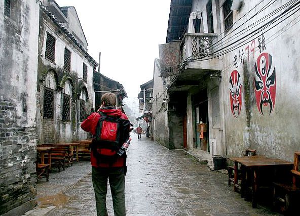 A tourist is exploring the ancient archetectures of Xingping ancient town